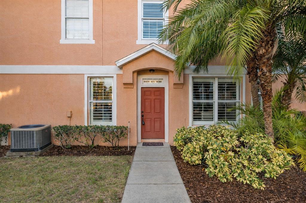 8408 Shallow Creek Court New Port Richey, FL 34653 - Photo 5 of 47 a front view of a house with a yard and potted plants