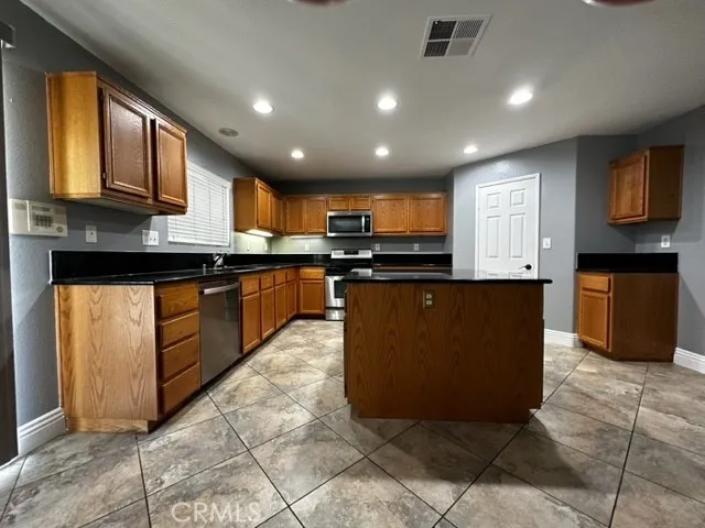 a kitchen with stainless steel appliances granite countertop a stove top oven a sink a counter top space and cabinets