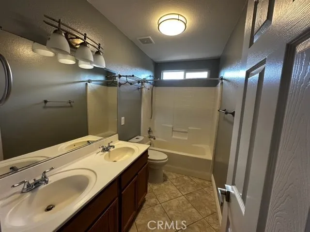 a bathroom with a double vanity sink a large mirror and shower