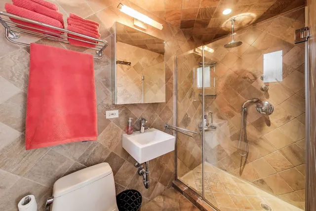 a bathroom with a toilet sink mirror and shower