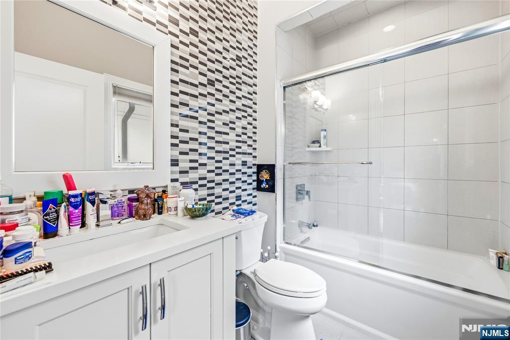 1228 River Road Edgewater, NJ 07020 - Photo 21 of 49 a bathroom with a sink mirror toilet and bathtub
