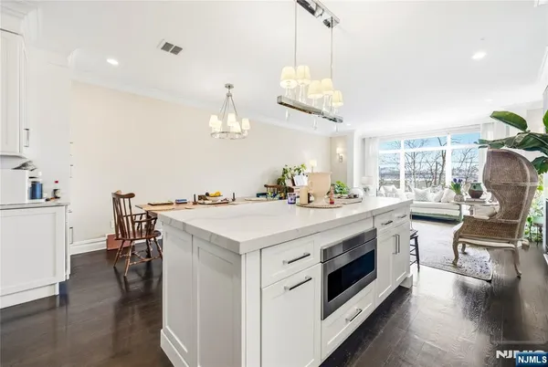 a kitchen with a stove and wooden floor