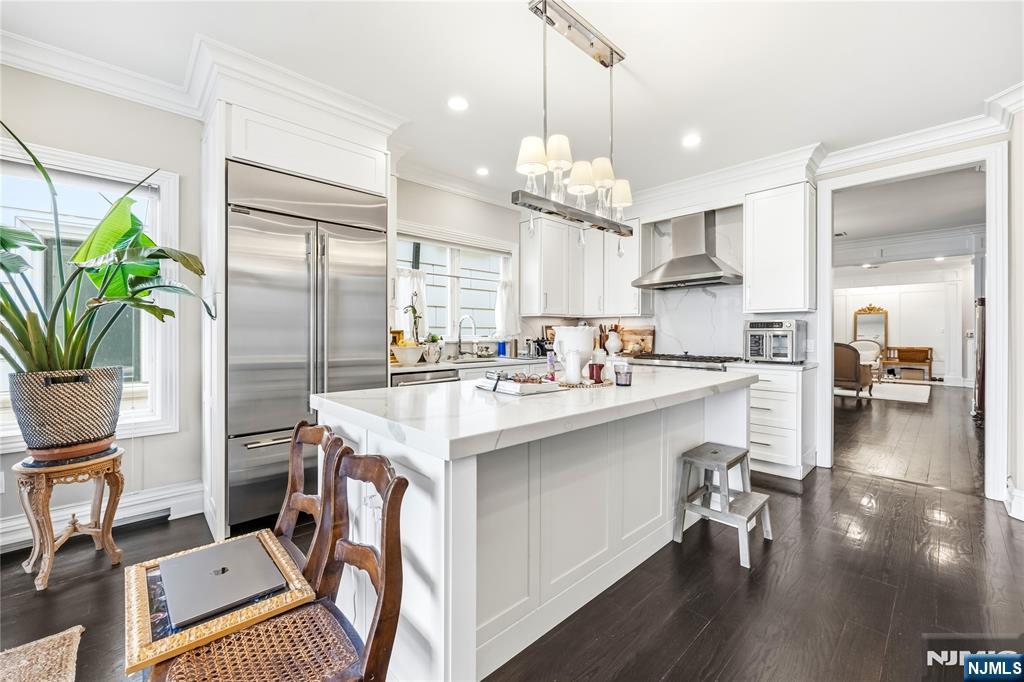 1228 River Road Edgewater, NJ 07020 - Photo 9 of 49 a open kitchen with stainless steel appliances granite countertop a refrigerator a stove a sink dishwasher a dining table and chairs with wooden floor