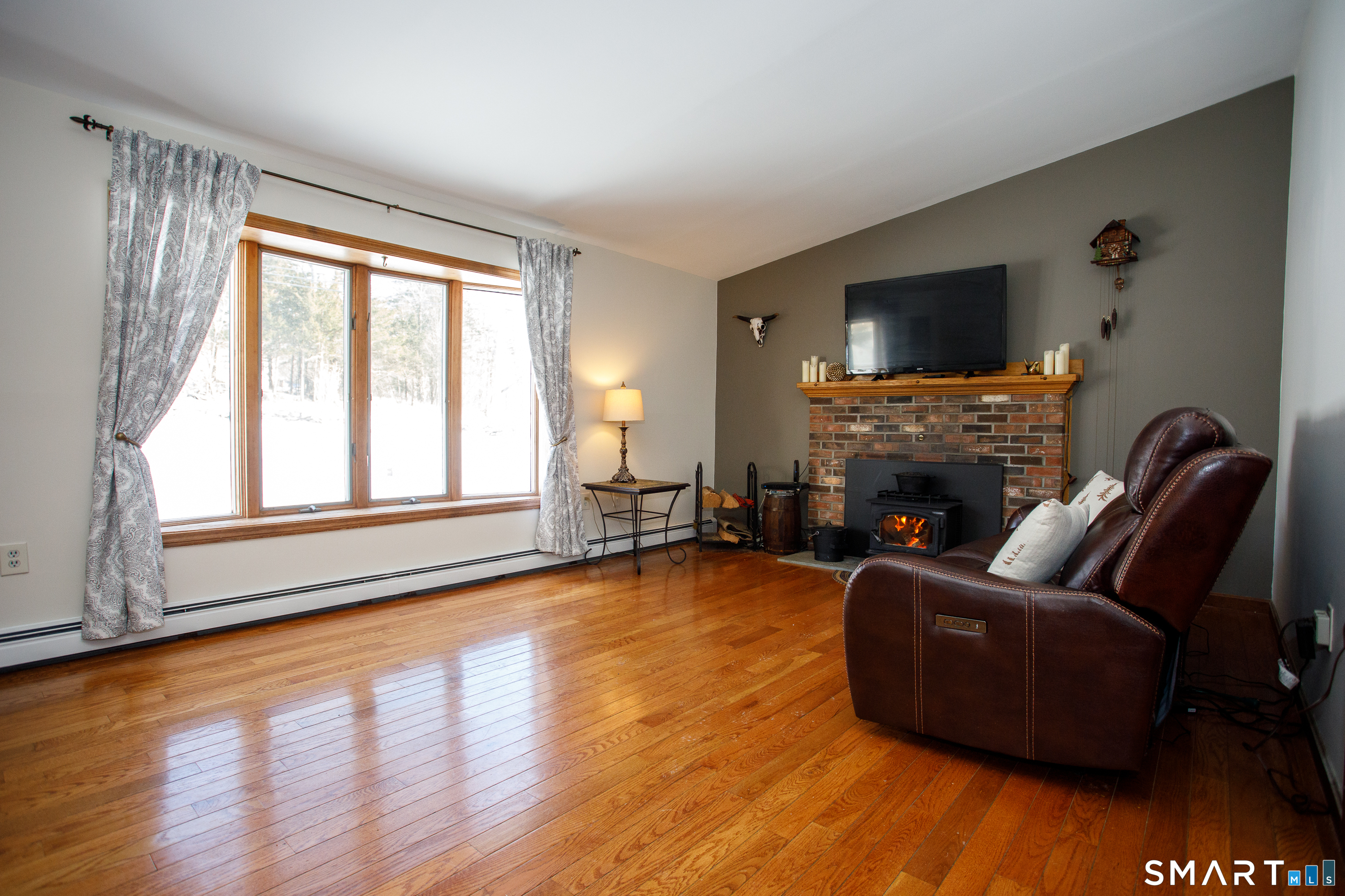 110 Pautipaug Hill Road Sprague, CT 06330 - Photo 15 of 33 a living room with furniture a flat screen tv and a fireplace