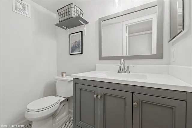 a bathroom with a toilet a sink and mirror