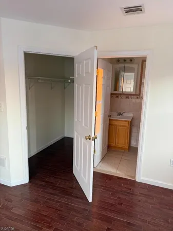 an empty room with wooden floor cabinet and cabinet