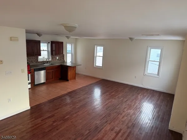 a large kitchen with cabinets wooden floor and stainless steel appliances