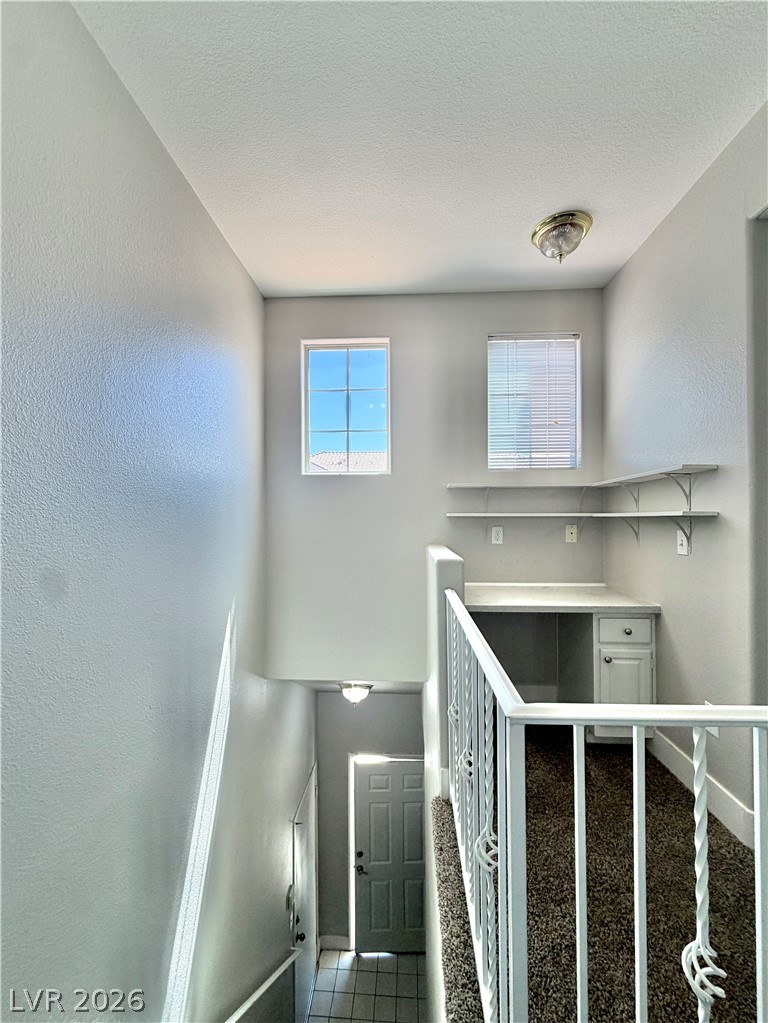 8555 West Russell Road, Unit 2018 Las Vegas, NV 89113 - Photo 11 of 23 A clever office nook with built-in desk and shelves is carved into this bright landing above a tiled entry.