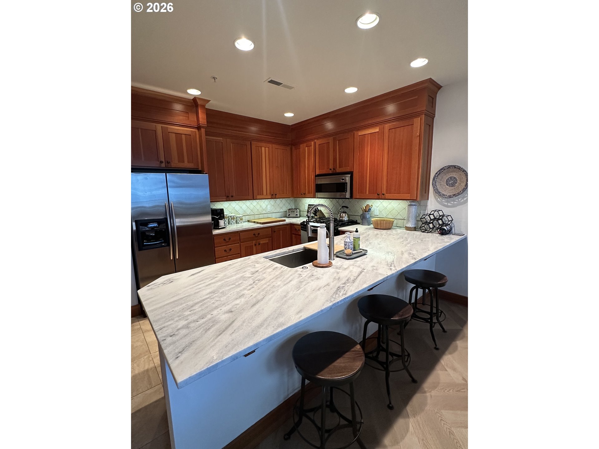 3912 Sunset Boulevard, Unit A202 Seaside, OR 97138 - Photo 11 of 32 a kitchen with a sink refrigerator and cabinets