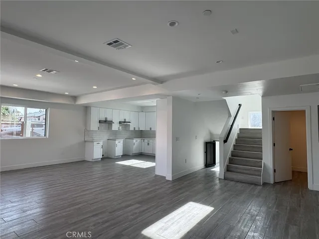 a view of a hallway with wooden floor and entryway