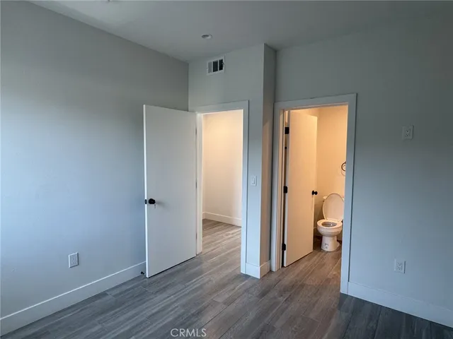 a view of a room with wooden floor and a bathroom