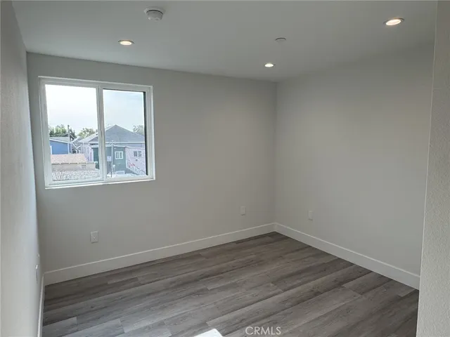 an empty room with wooden floor and a window