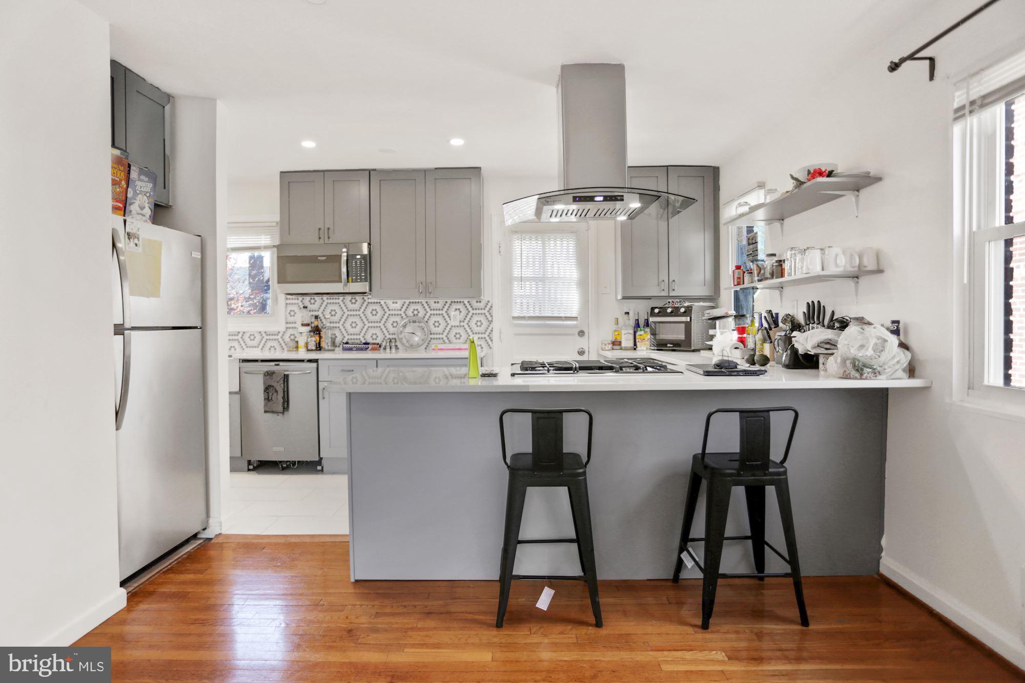 4910 Sargent Road Northeast Washington, DC 20017 - Photo 4 of 16 a kitchen with stainless steel appliances granite countertop a table chairs stove and refrigerator