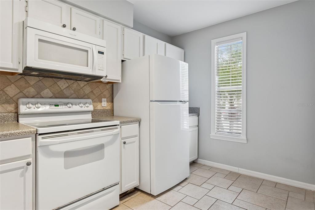 11356 Stratton Park Drive Temple Terrace, FL 33617 - Photo 6 of 25 a kitchen with white cabinets and white appliances
