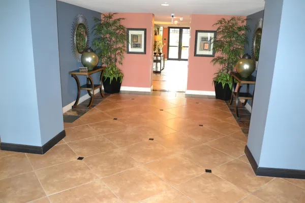 a living room with furniture a flat screen tv and a floor to ceiling window