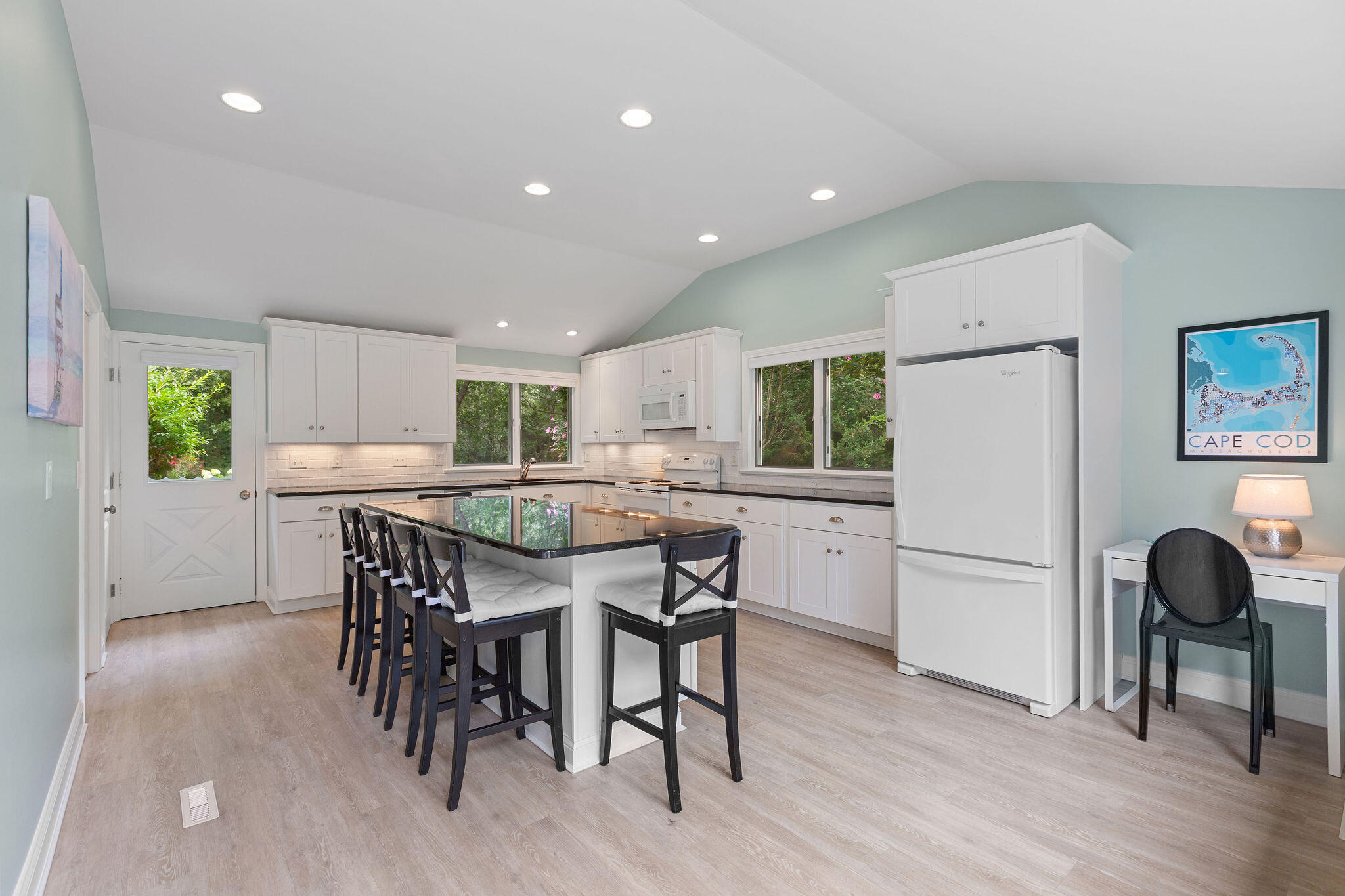 75 Monument Road Orleans, MA 02653 - Photo 29 of 61 a kitchen with stainless steel appliances a dining table chairs refrigerator and sink