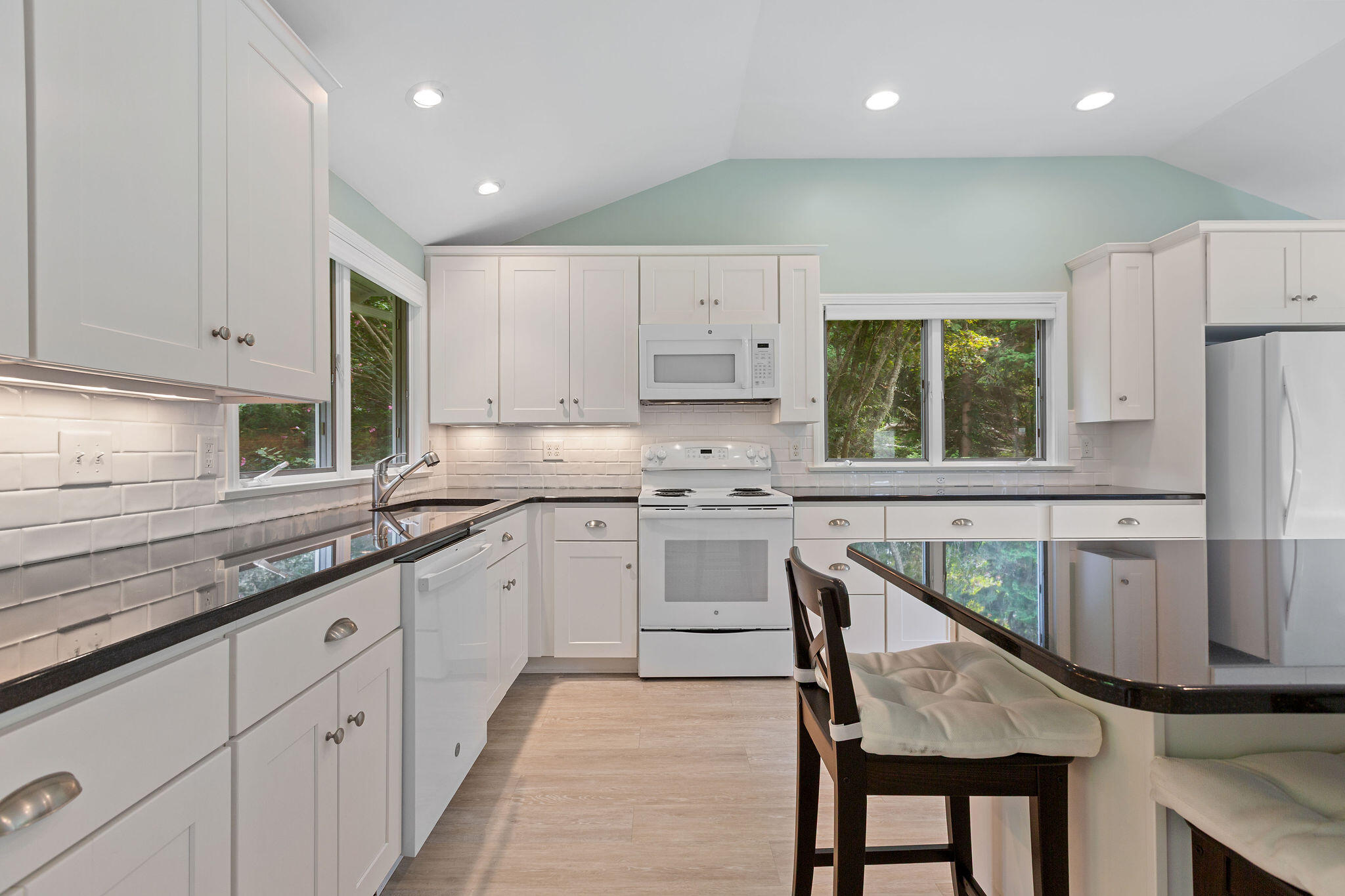 75 Monument Road Orleans, MA 02653 - Photo 33 of 61 a kitchen that has a lot of cabinets in it with stainless steel appliances granite countertop a stove a sink a refrigerator and white cabinets