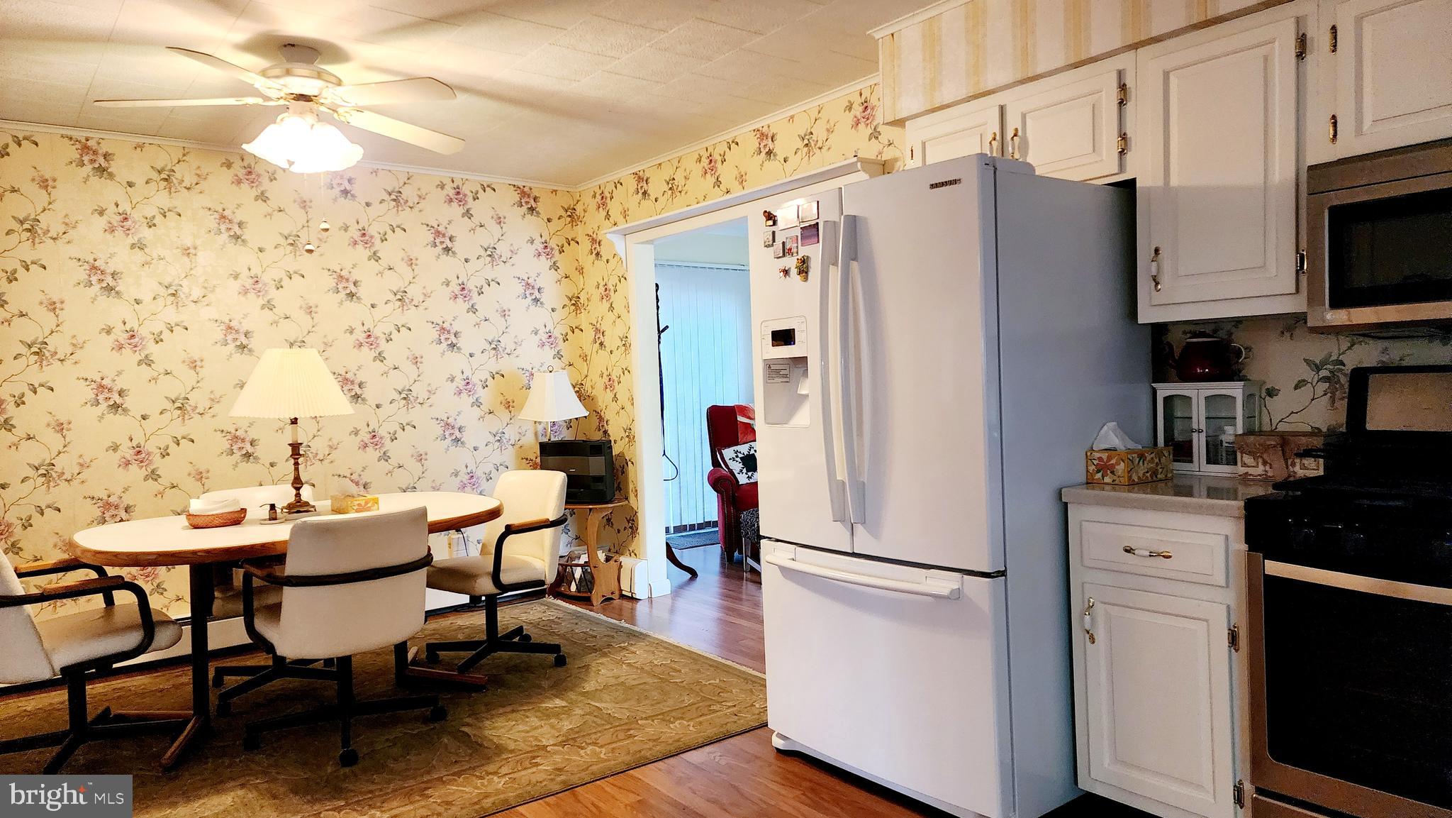 140 Water Street Fairfield, PA 17320 - Photo 12 of 40 a kitchen with stainless steel appliances a refrigerator a stove a dining table and chairs with wooden floor
