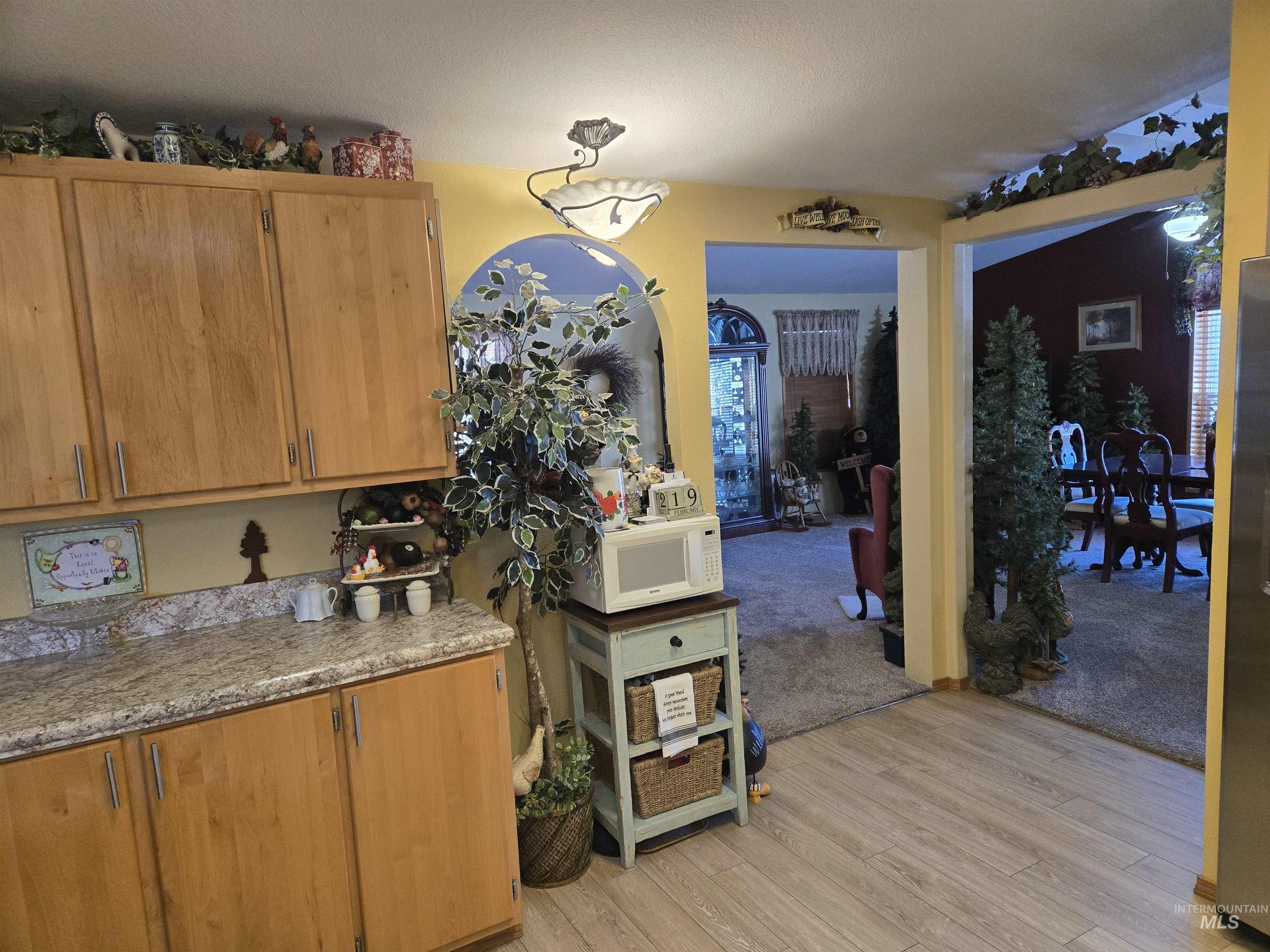 254 Lackey Road Weippe, ID 83553 - Photo 6 of 37 Kitchen with wood finish cabinets, light wood-style flooring, white microwave, and freestanding refrigerator