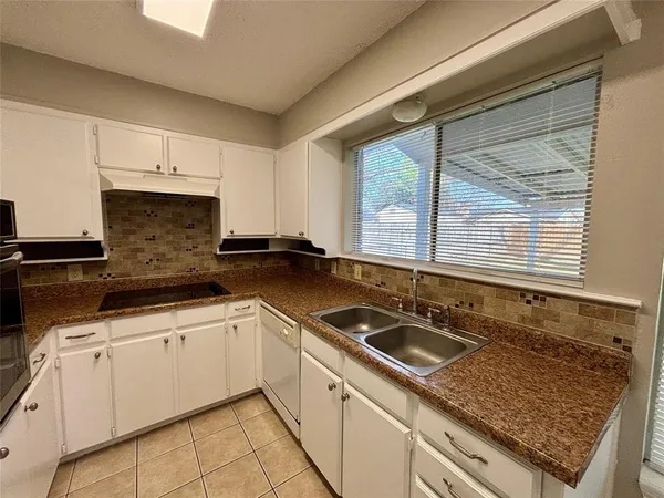 a kitchen with granite countertop a sink and a stove