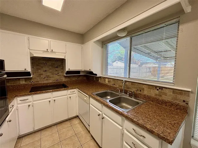 a kitchen with granite countertop a sink and a stove