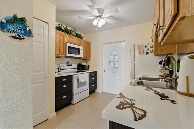a kitchen with stainless steel appliances granite countertop a sink dishwasher and a refrigerator with wooden cabinets