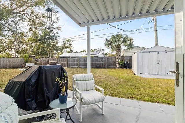 a view of a patio with table and chairs with wooden floor and fence