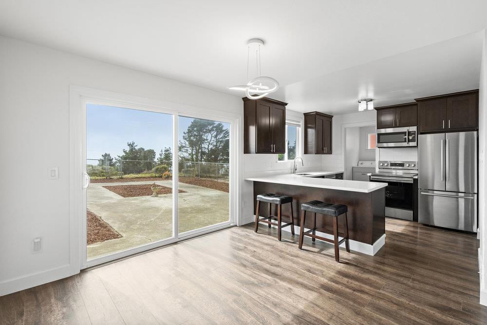 418 Imperial Drive Pacifica, CA 94044 - Photo 15 of 70 a large kitchen with a table chairs refrigerator and microwave