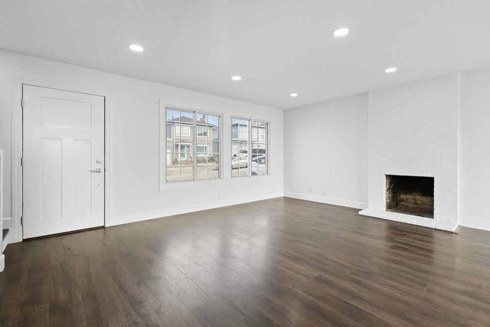418 Imperial Drive Pacifica, CA 94044 - Photo 19 of 70 an empty room with wooden floor and fireplace