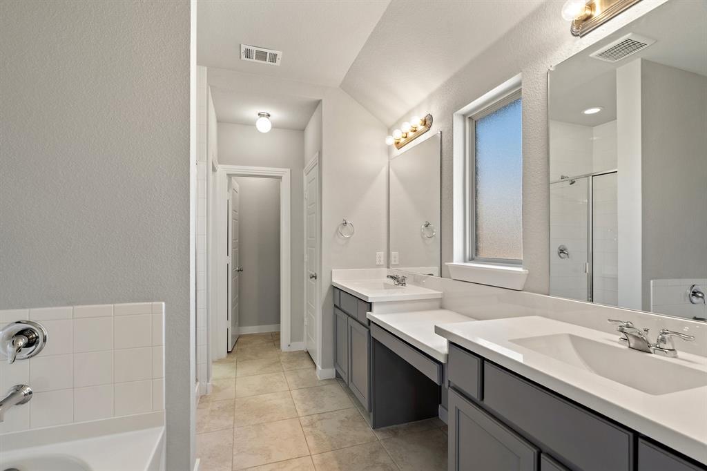 1401 Macaw Court Little Elm, TX 75068 - Photo 11 of 25 Full bathroom with two vanities, a garden tub, a textured wall, a stall shower, and tile patterned floors