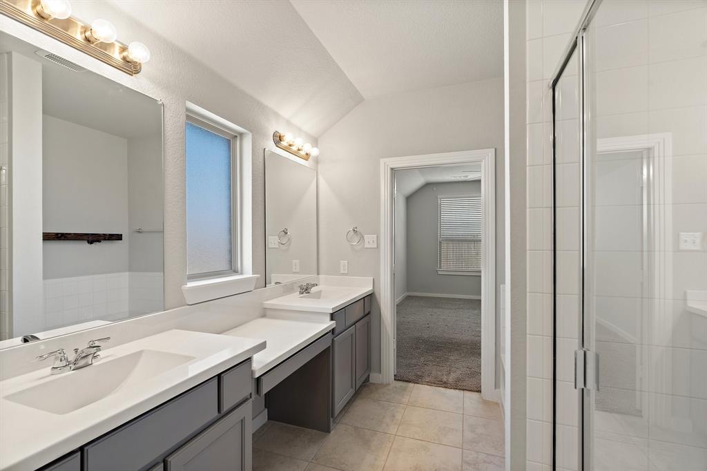 1401 Macaw Court Little Elm, TX 75068 - Photo 13 of 25 Bathroom with tile patterned flooring, vanity, a stall shower, and vaulted ceiling