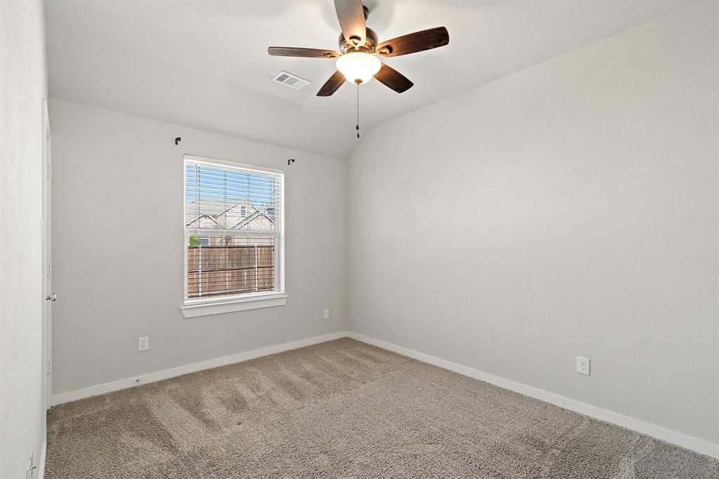 1401 Macaw Court Little Elm, TX 75068 - Photo 15 of 25 Carpeted spare room featuring lofted ceiling and a ceiling fan