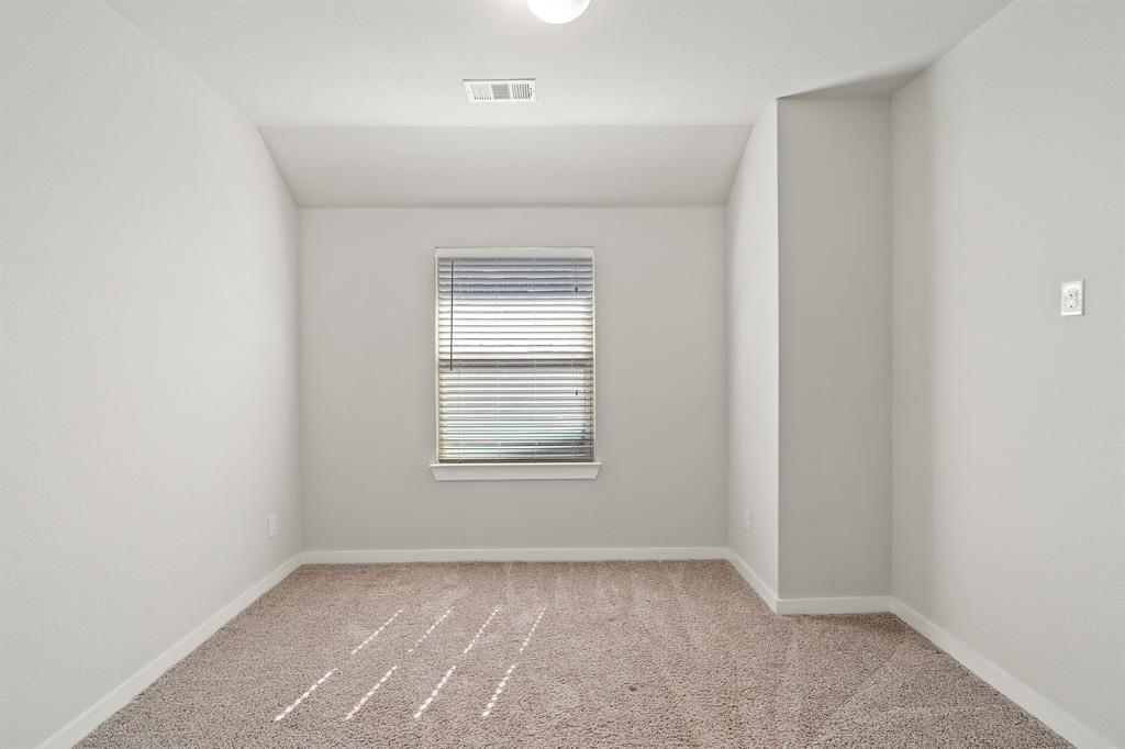 1401 Macaw Court Little Elm, TX 75068 - Photo 16 of 25 Carpeted empty room with baseboards and lofted ceiling
