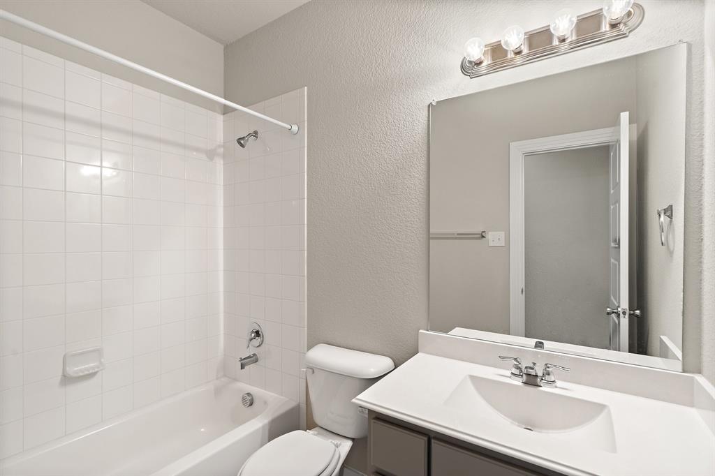 1401 Macaw Court Little Elm, TX 75068 - Photo 17 of 25 Bathroom featuring a textured wall, vanity, and shower / washtub combination