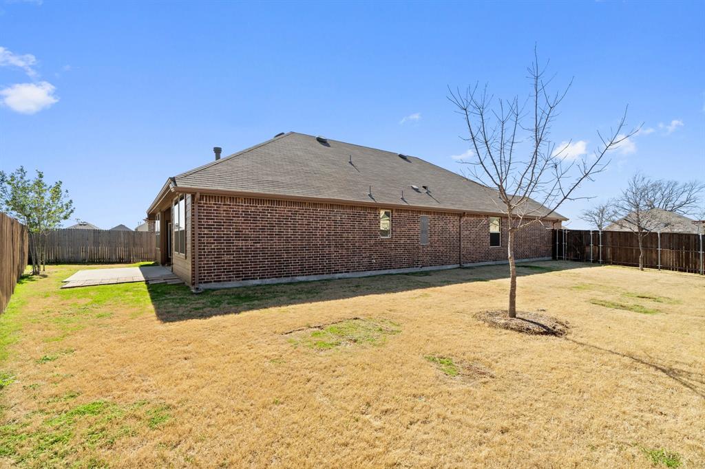 1401 Macaw Court Little Elm, TX 75068 - Photo 22 of 25 Back of house with a fenced backyard, a patio area, brick siding, and a shingled roof