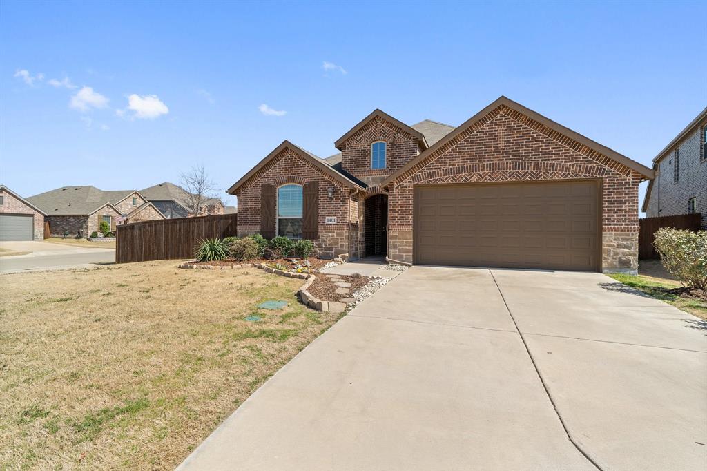 1401 Macaw Court Little Elm, TX 75068 - Photo 23 of 25 View of front facade featuring a garage, brick siding, driveway, and stone siding