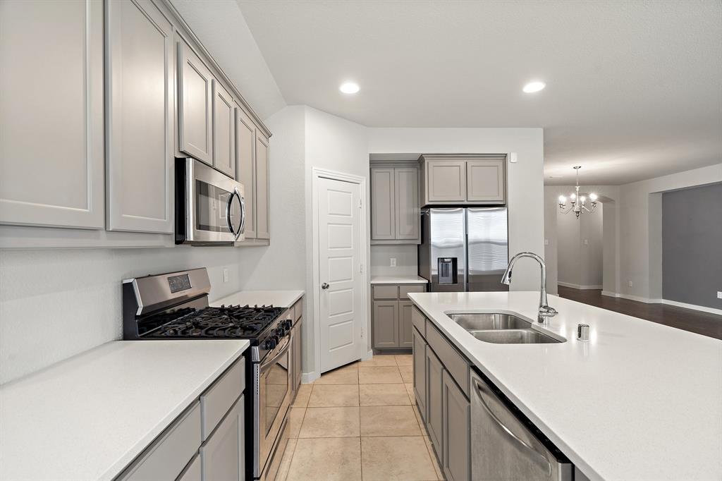 1401 Macaw Court Little Elm, TX 75068 - Photo 5 of 25 Kitchen featuring gray cabinetry, stainless steel appliances, recessed lighting, light countertops, and a chandelier