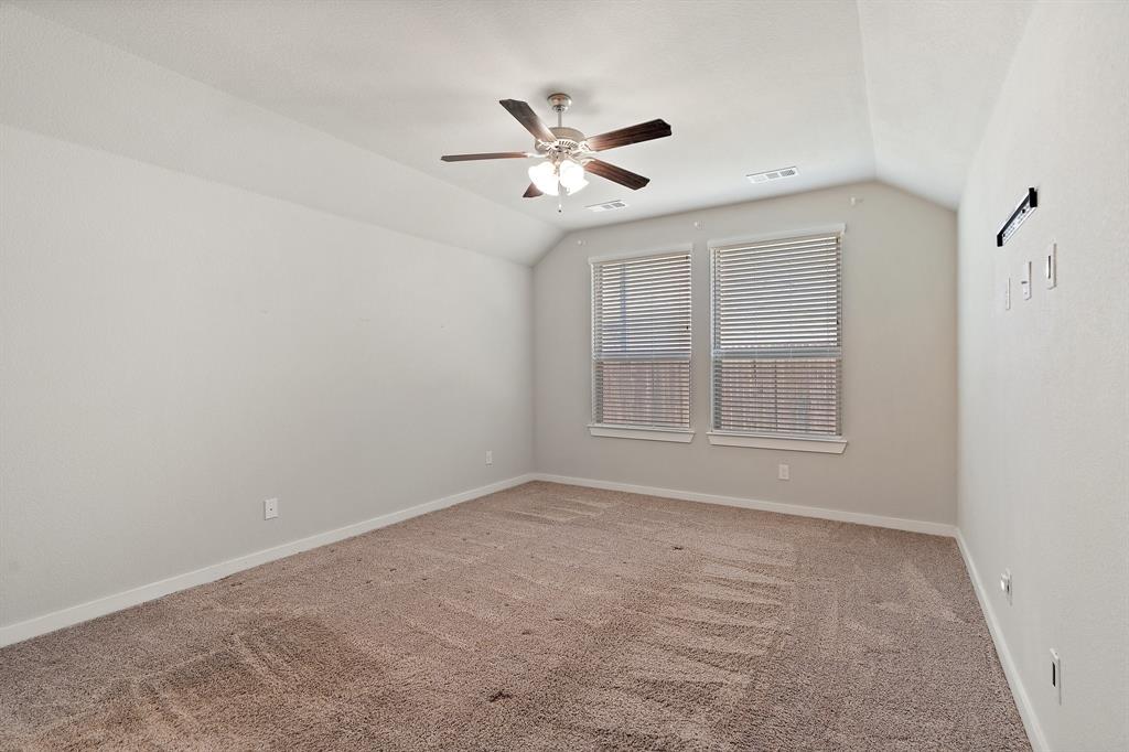 1401 Macaw Court Little Elm, TX 75068 - Photo 10 of 25 Empty room with light colored carpet, lofted ceiling, and a ceiling fan