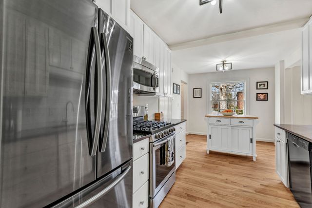 a kitchen with stainless steel appliances granite countertop a stove and cabinets