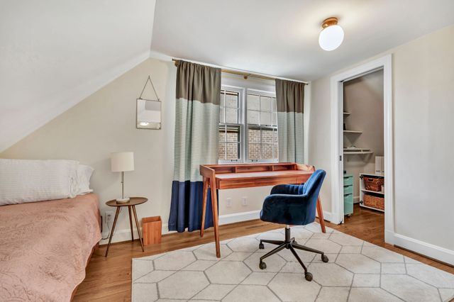 a view of hallway with furniture and wooden floor