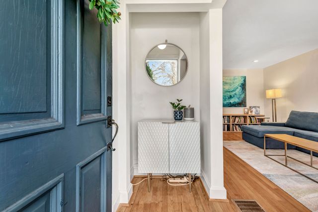 a bedroom with a bed a mirror and a potted plant