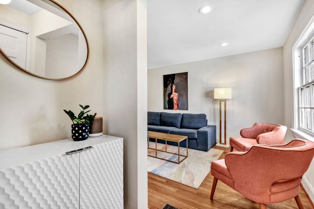 a living room with furniture a rug and a window