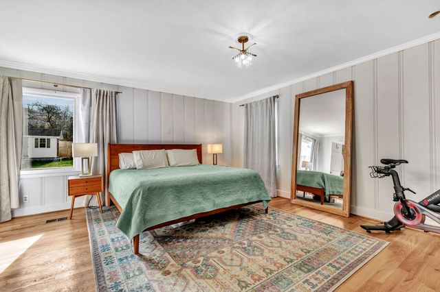 a bedroom with a bed and wooden floor