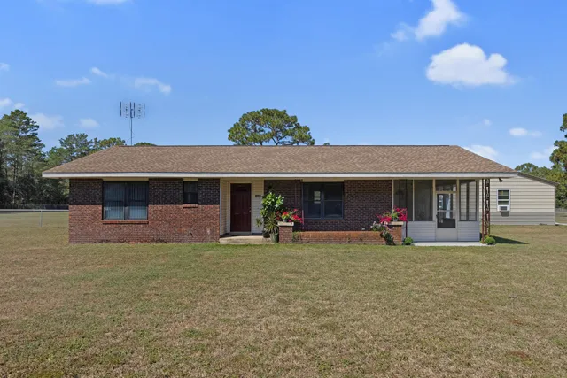 a view of a house with a yard and sitting area