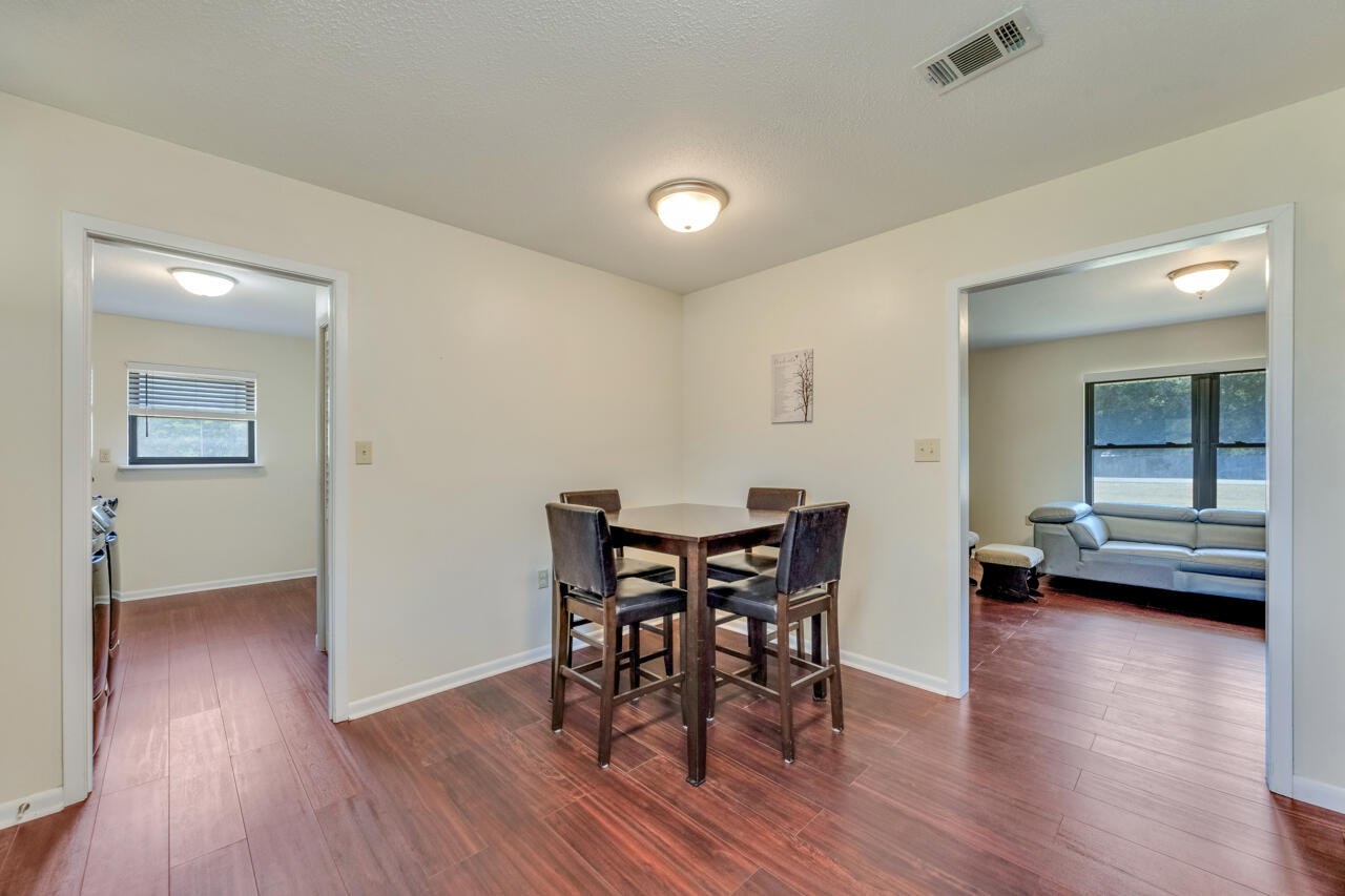 5448 Mt Olive Road Crestview, FL 32539 - Photo 13 of 37 a view of a dining room with furniture and wooden floor