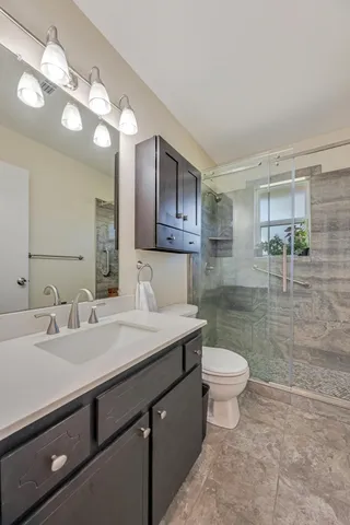 a bathroom with a sink a toilet and shower