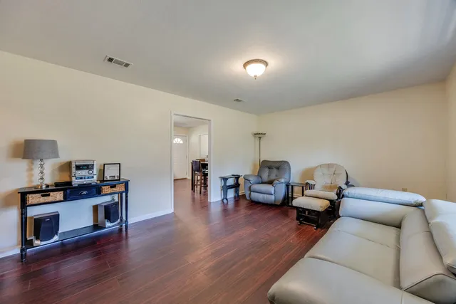 a living room with furniture and a wooden floor
