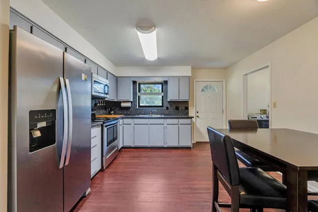 a kitchen with stainless steel appliances granite countertop a refrigerator a stove and a sink