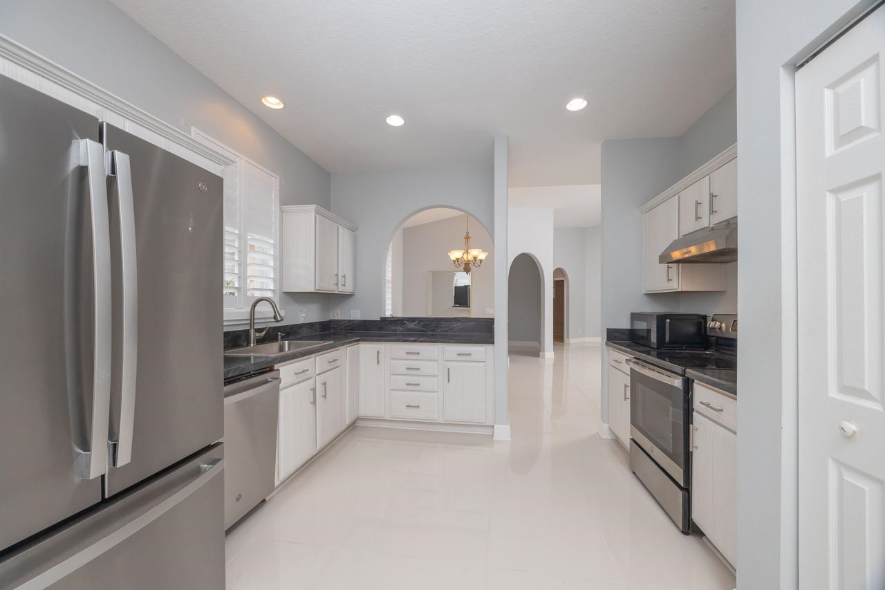 573 Boxwood Place St. Augustine, FL 32086 - Photo 20 of 40 a kitchen with granite countertop a refrigerator stove and sink