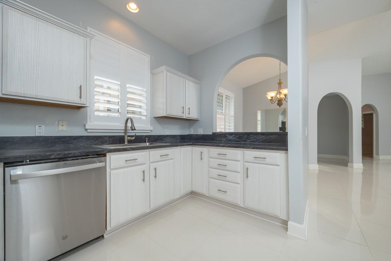 573 Boxwood Place St. Augustine, FL 32086 - Photo 21 of 40 a kitchen with granite countertop white cabinets and sink